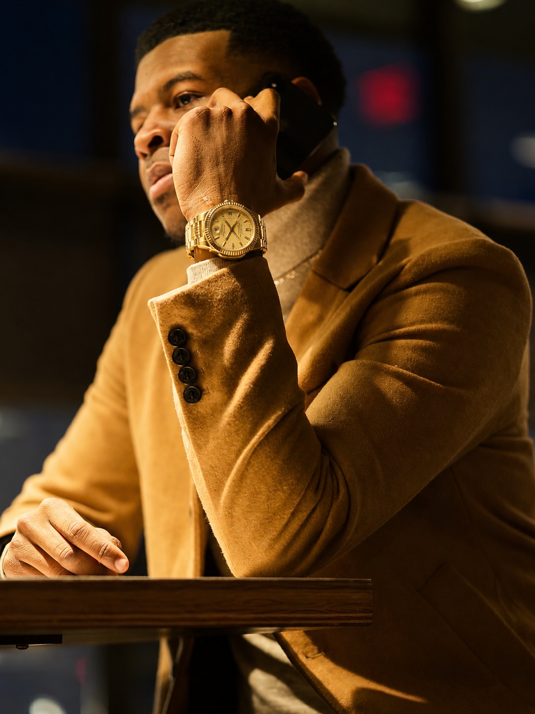 DreShotz in a tan jacket and gold watch